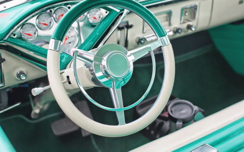 Close-up of vintage car interior with retro steering wheel and dashboard