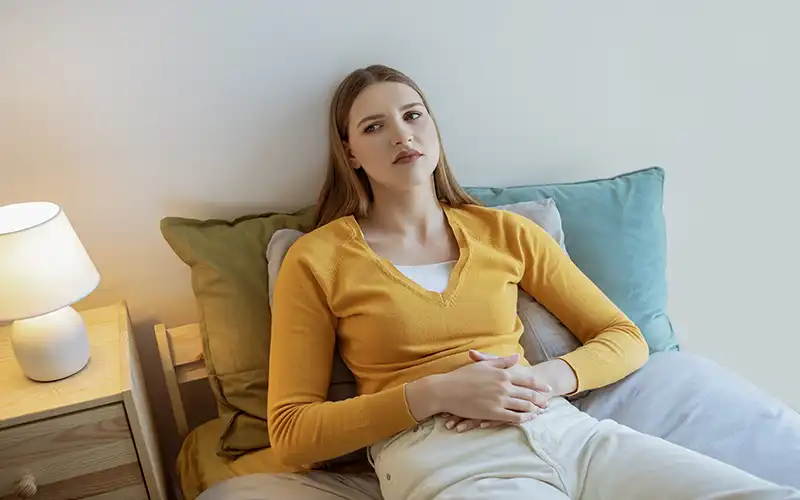 Stomach pain woman looking uncomfortable — H. pylori infection risk